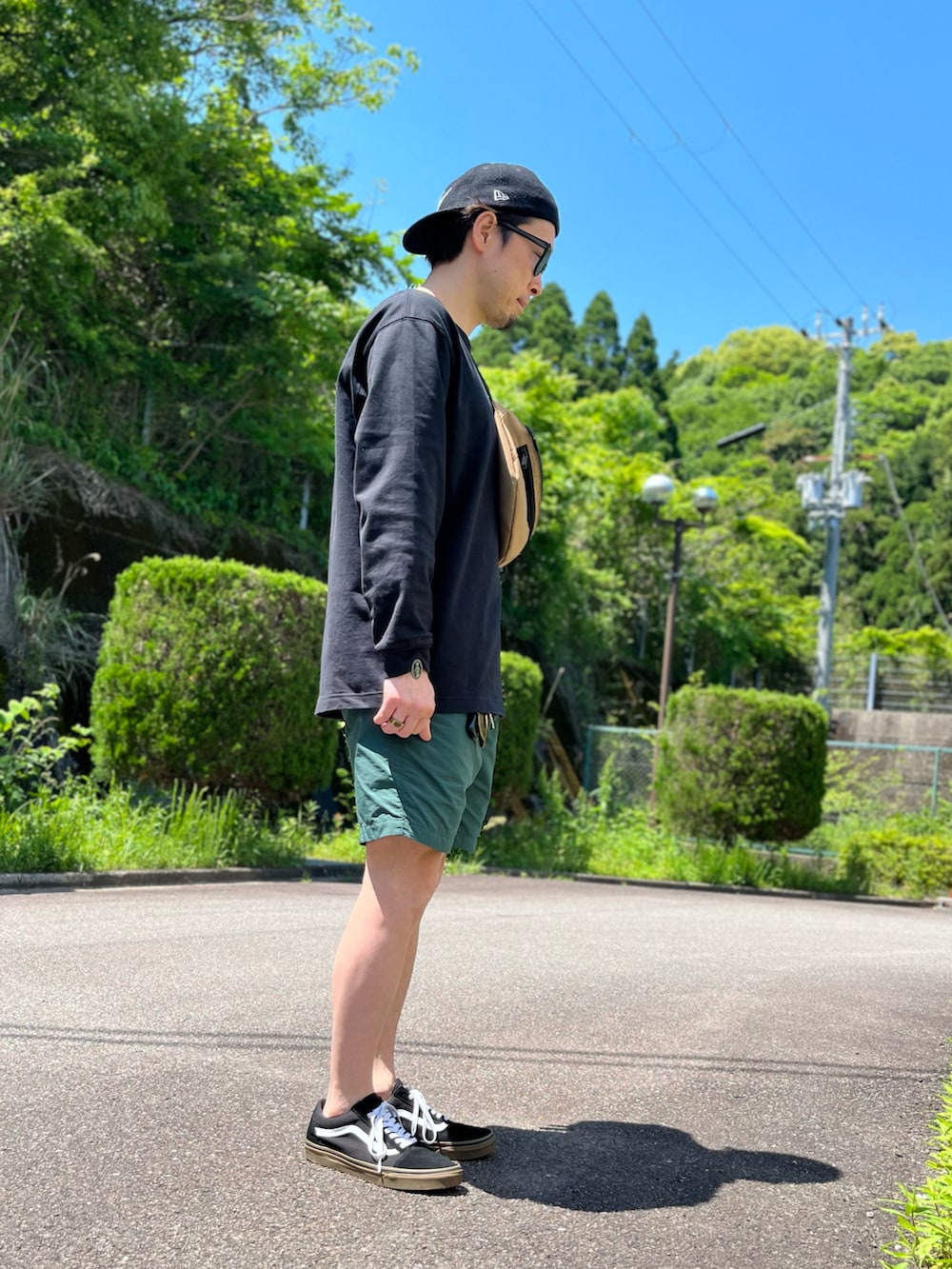 ホワイト系のTシャツ/カットソー、グリーン系のその他パンツ、ブラック系のスニーカーを着用したメンズの春コーディネートの2枚目の写真
