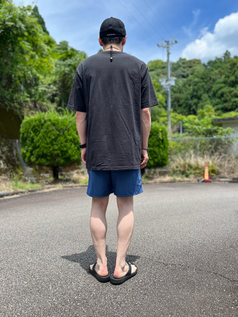 ブラック系のTシャツ/カットソー、ブルー系のパンツ、ブラック系のサンダルを着用したメンズの夏コーディネートの4枚目の写真