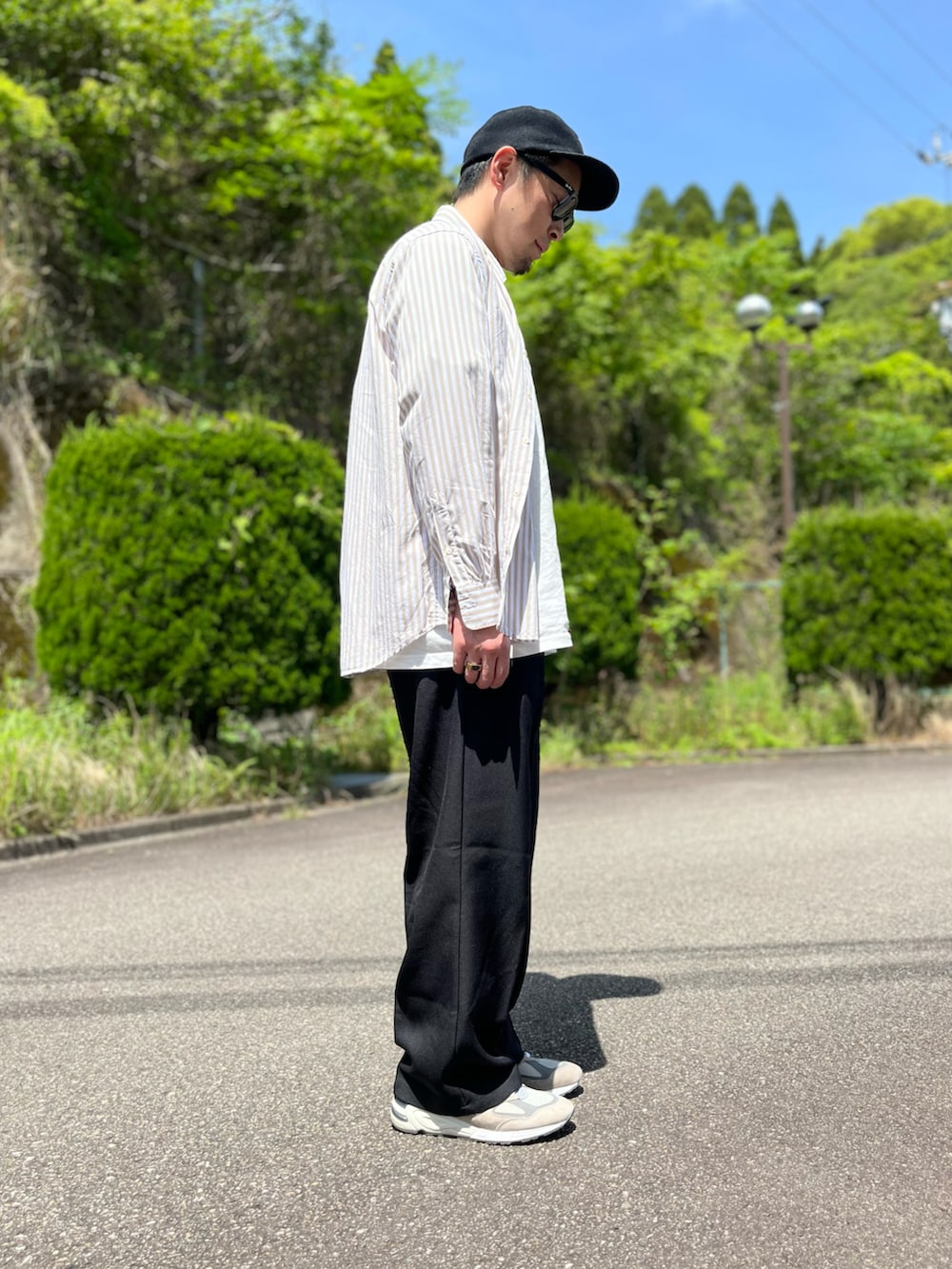 ホワイト系のTシャツ/カットソー、ブラウン系のシャツ/ブラウス、ブラック系のスラックスを着用したメンズの春コーディネートの2枚目の写真