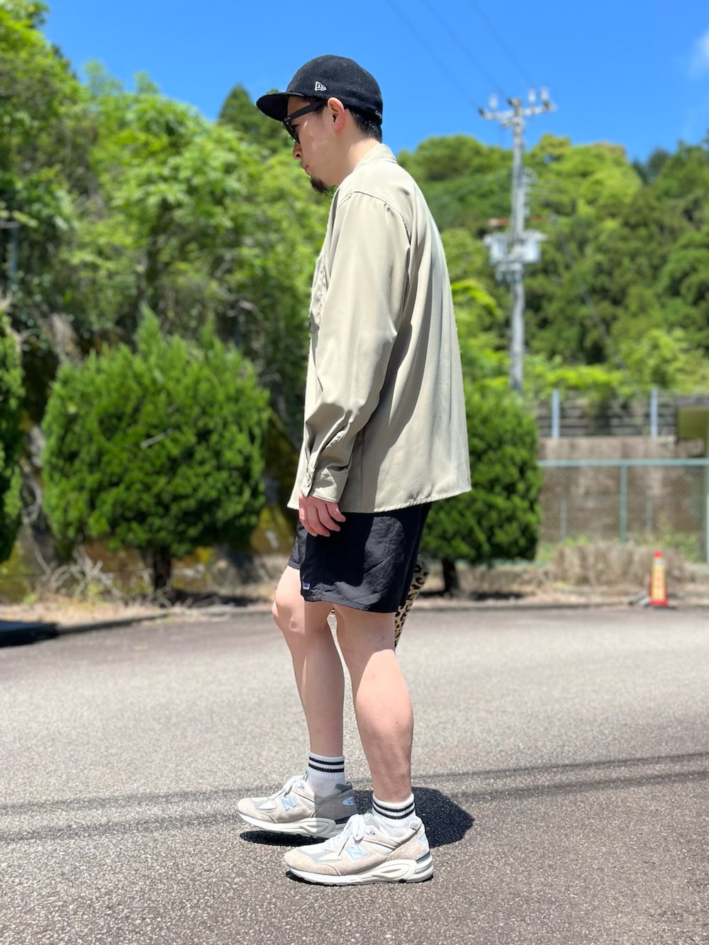 ブラック系のその他パンツ、その他のクラッチバッグ、グレー系のスニーカーを着用したメンズの春コーディネートの4枚目の写真