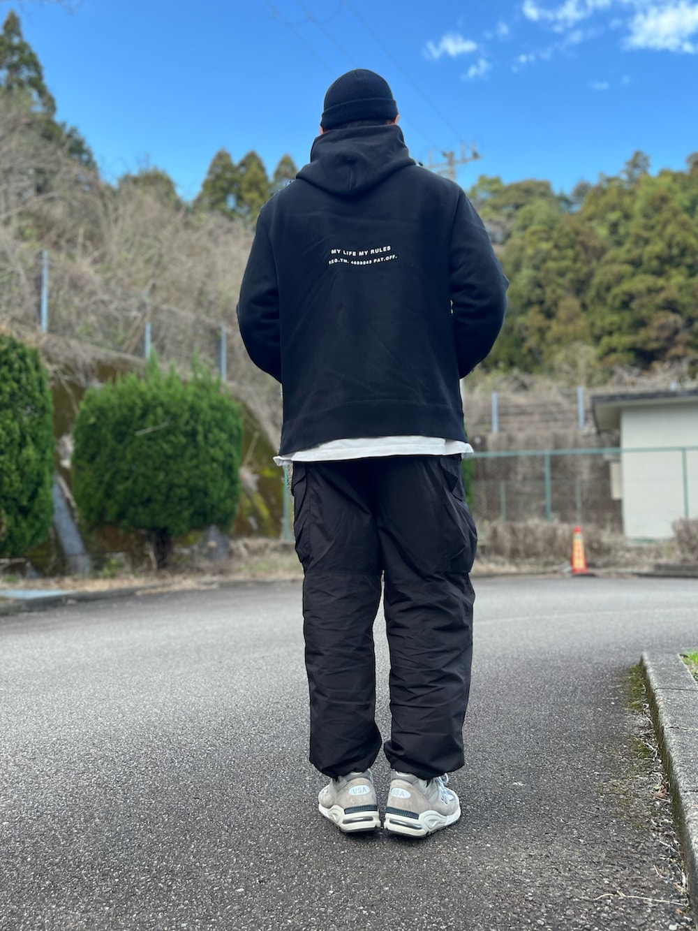 ブラック系のパーカー、ホワイト系のTシャツ/カットソー、グレー系のスニーカーを着用したメンズの冬コーディネートの3枚目の写真