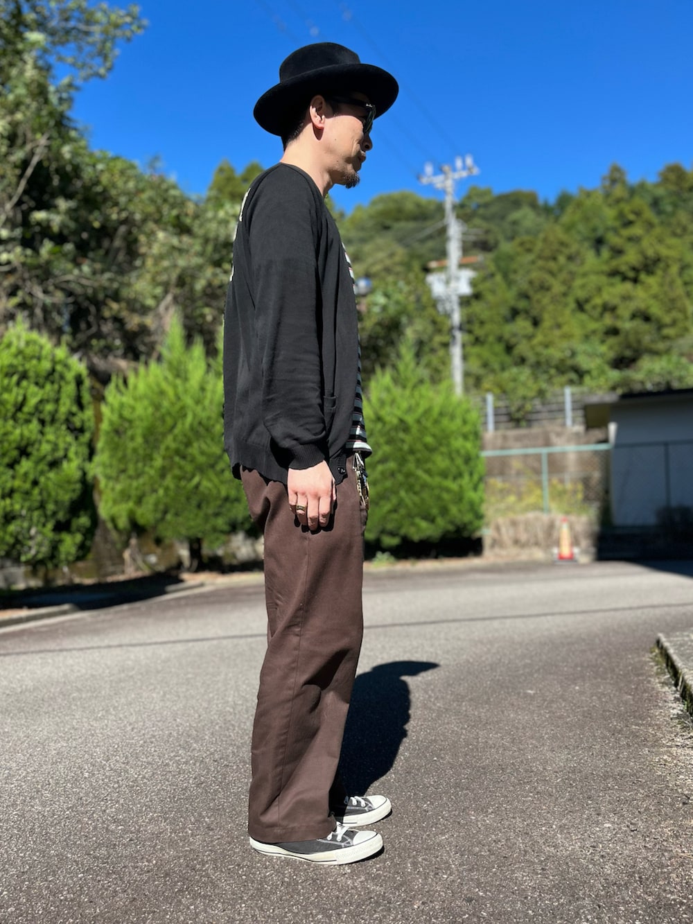 ブラック系のTシャツ/カットソー、ブラック系のカーディガン/ボレロ、ブラウン系のチノパンツを着用したメンズの秋コーディネートの2枚目の写真