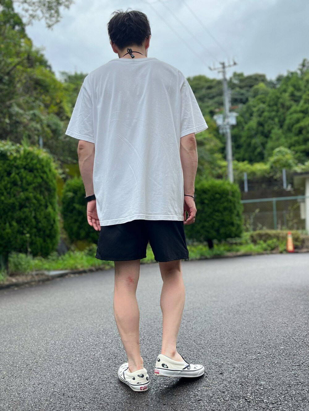 ホワイト系のTシャツ/カットソー、ブラック系のその他パンツ、ホワイト系のスリッポンを着用したメンズの夏コーディネートの3枚目の写真
