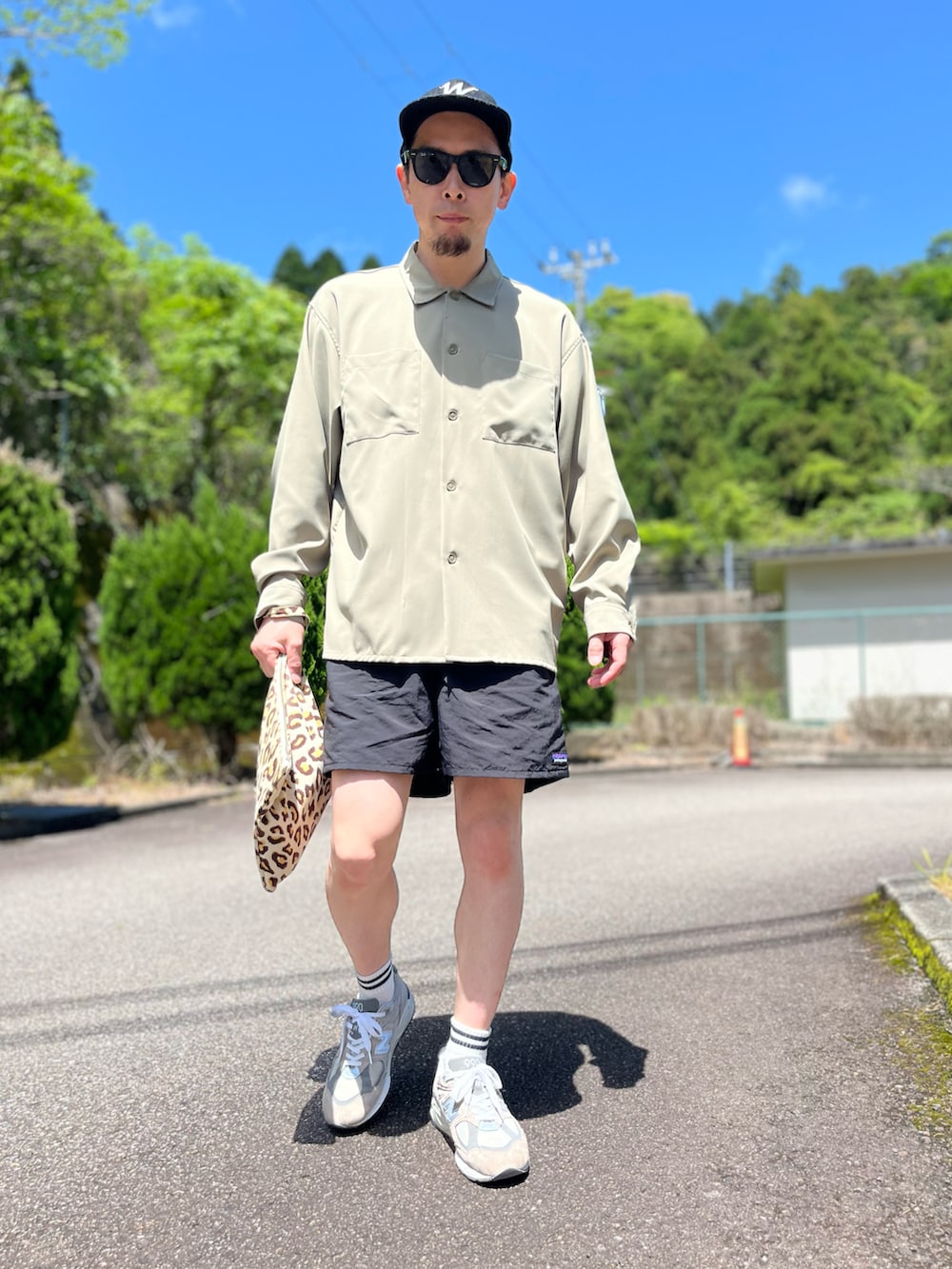 ブラック系のその他パンツ、その他のクラッチバッグ、グレー系のスニーカーを着用したメンズの春コーディネートの5枚目の写真