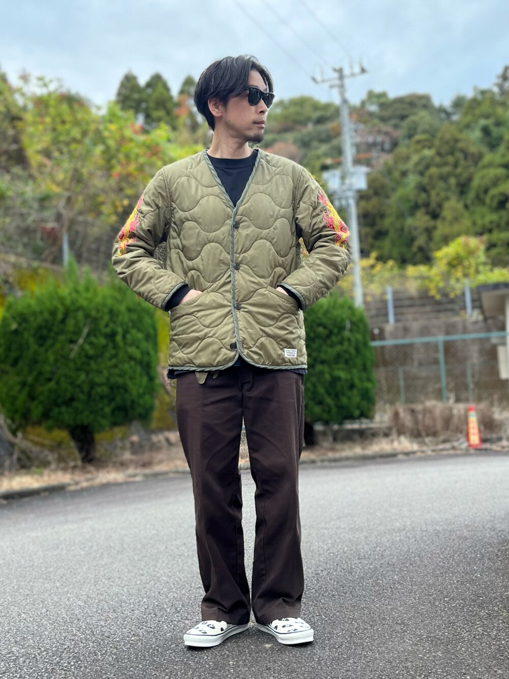 ホワイト系のTシャツ/カットソー、グリーン系のノーカラージャケット、ブラウン系のチノパンツを着用したメンズの冬コーディネートの5枚目の写真