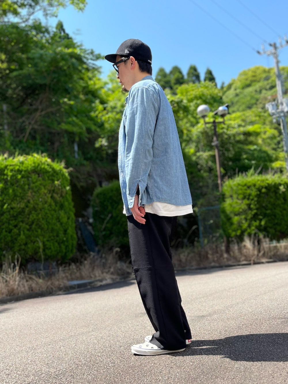 ホワイト系のTシャツ/カットソー、ブラック系のスラックス、ホワイト系のスリッポンを着用したメンズの春コーディネートの3枚目の写真