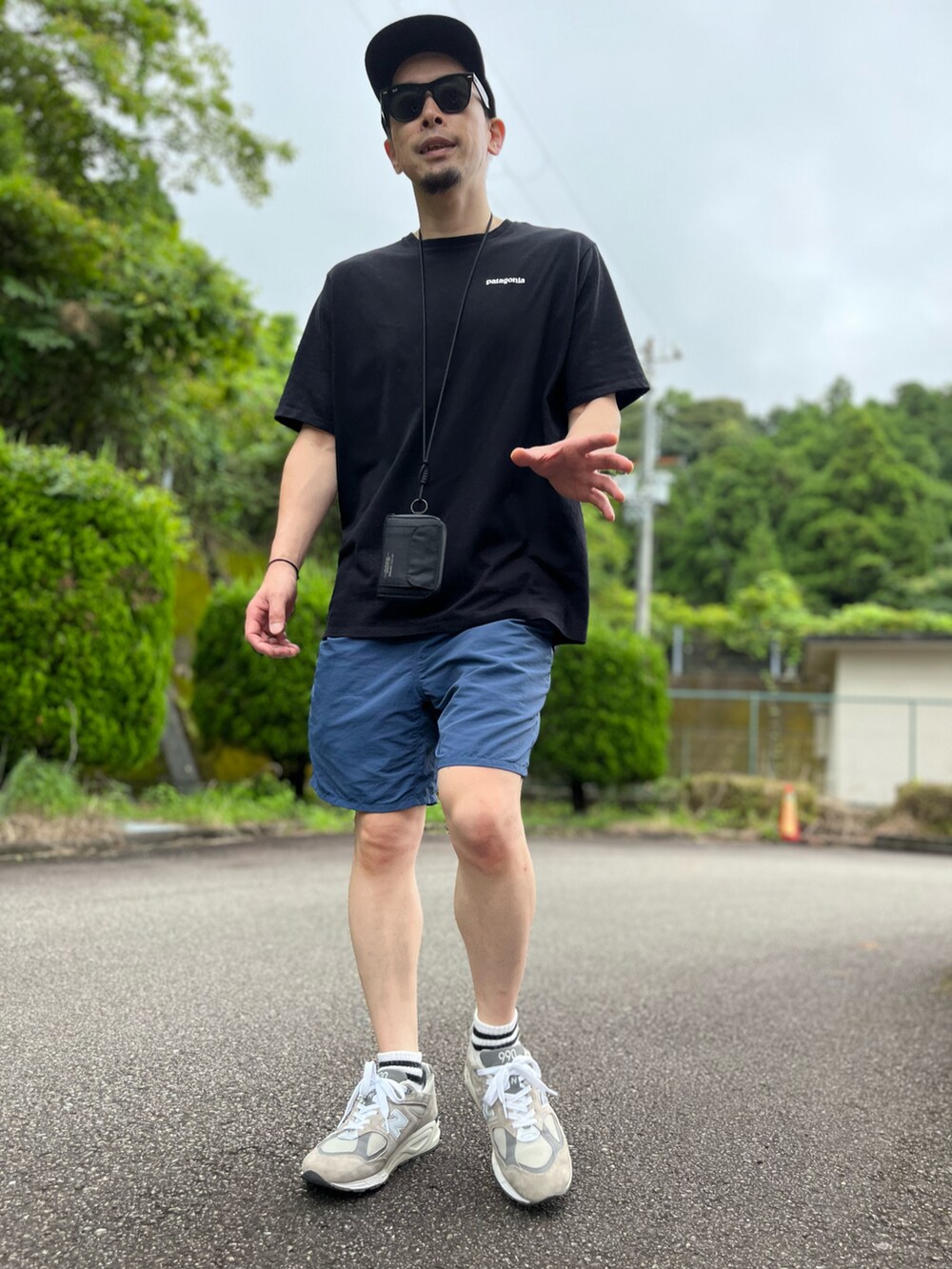 ブラック系のTシャツ/カットソー、ブルー系のパンツ、グレー系のスニーカーを着用したメンズの夏コーディネートの5枚目の写真