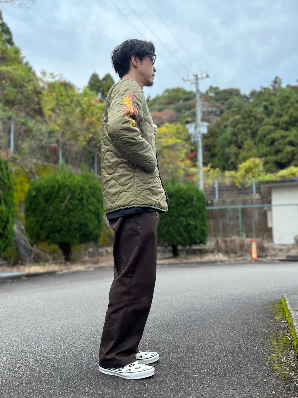 ホワイト系のTシャツ/カットソー、グリーン系のノーカラージャケット、ブラウン系のチノパンツを着用したメンズの冬コーディネートの4枚目の写真