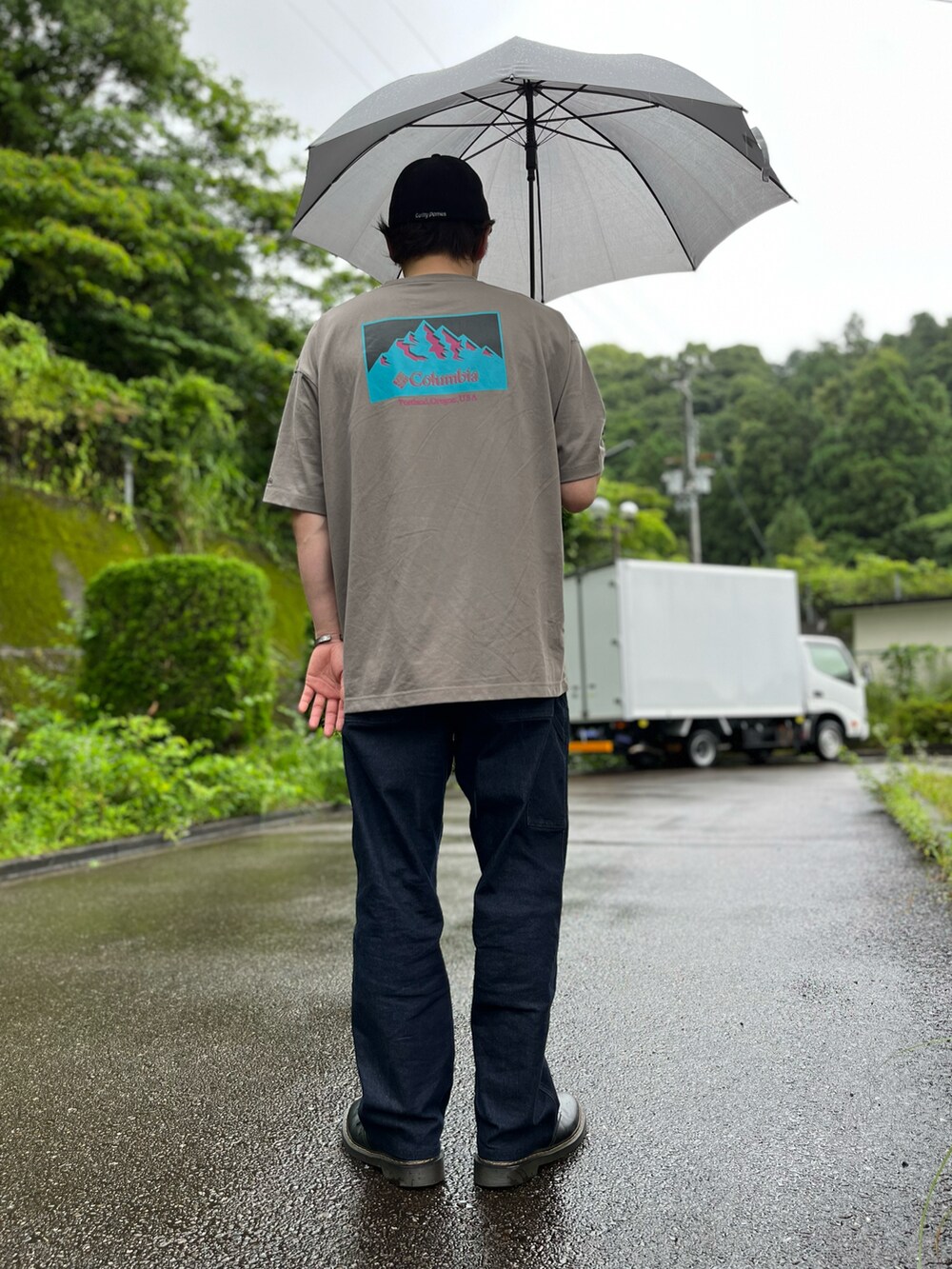 ブルー系のパンツ、ブラック系のブーツ、ブラウン系のTシャツ/カットソーを着用したメンズの夏コーディネートの2枚目の写真