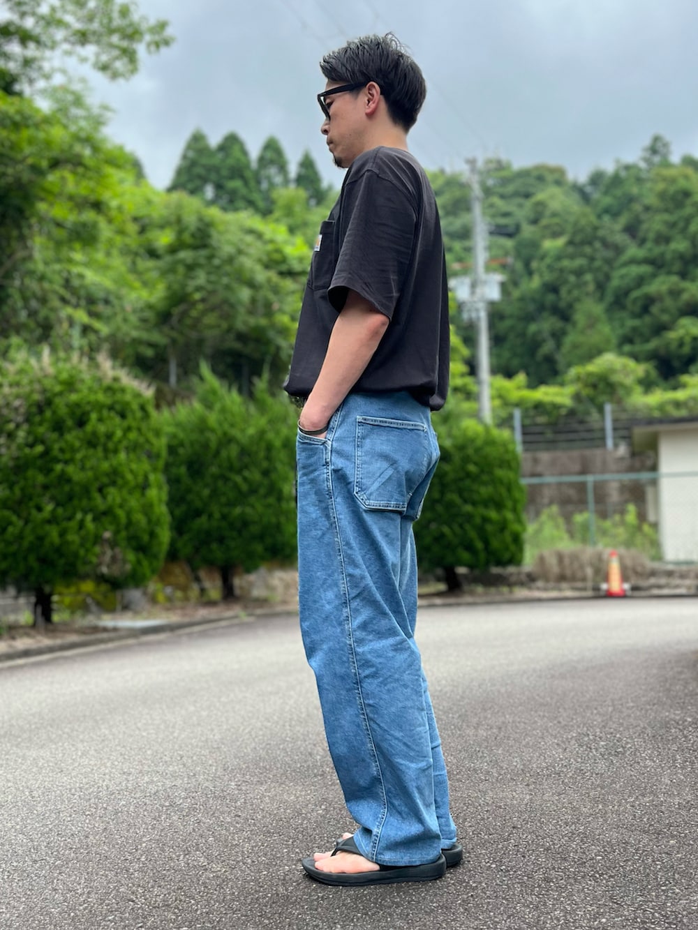 ブラック系のTシャツ/カットソー、ブルー系のパンツ、ブラック系のサンダルを着用したメンズの夏コーディネートの4枚目の写真
