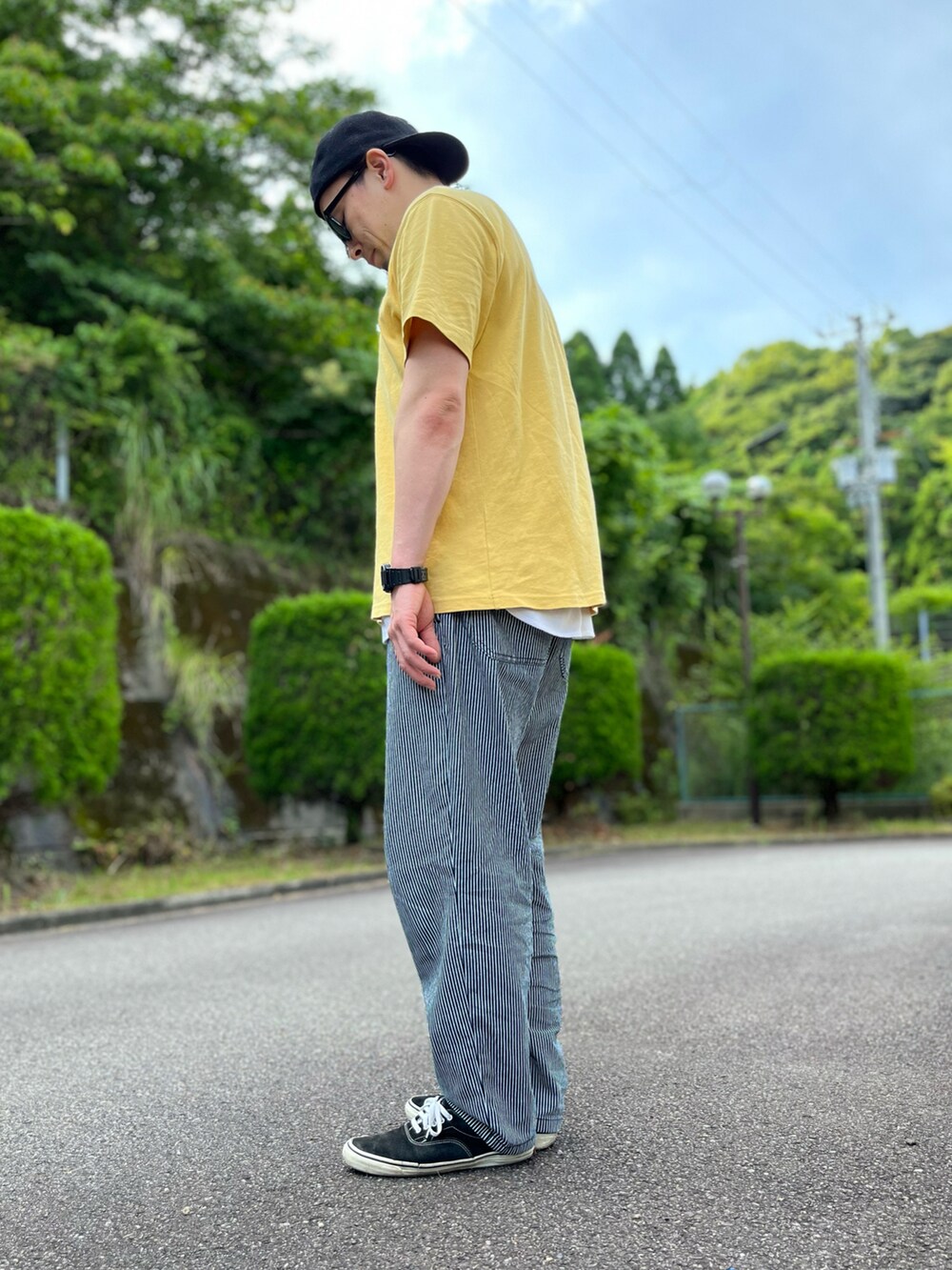 イエロー系のTシャツ/カットソー、ホワイト系のタンクトップ、グレー系のパンツを着用したメンズの夏コーディネートの4枚目の写真