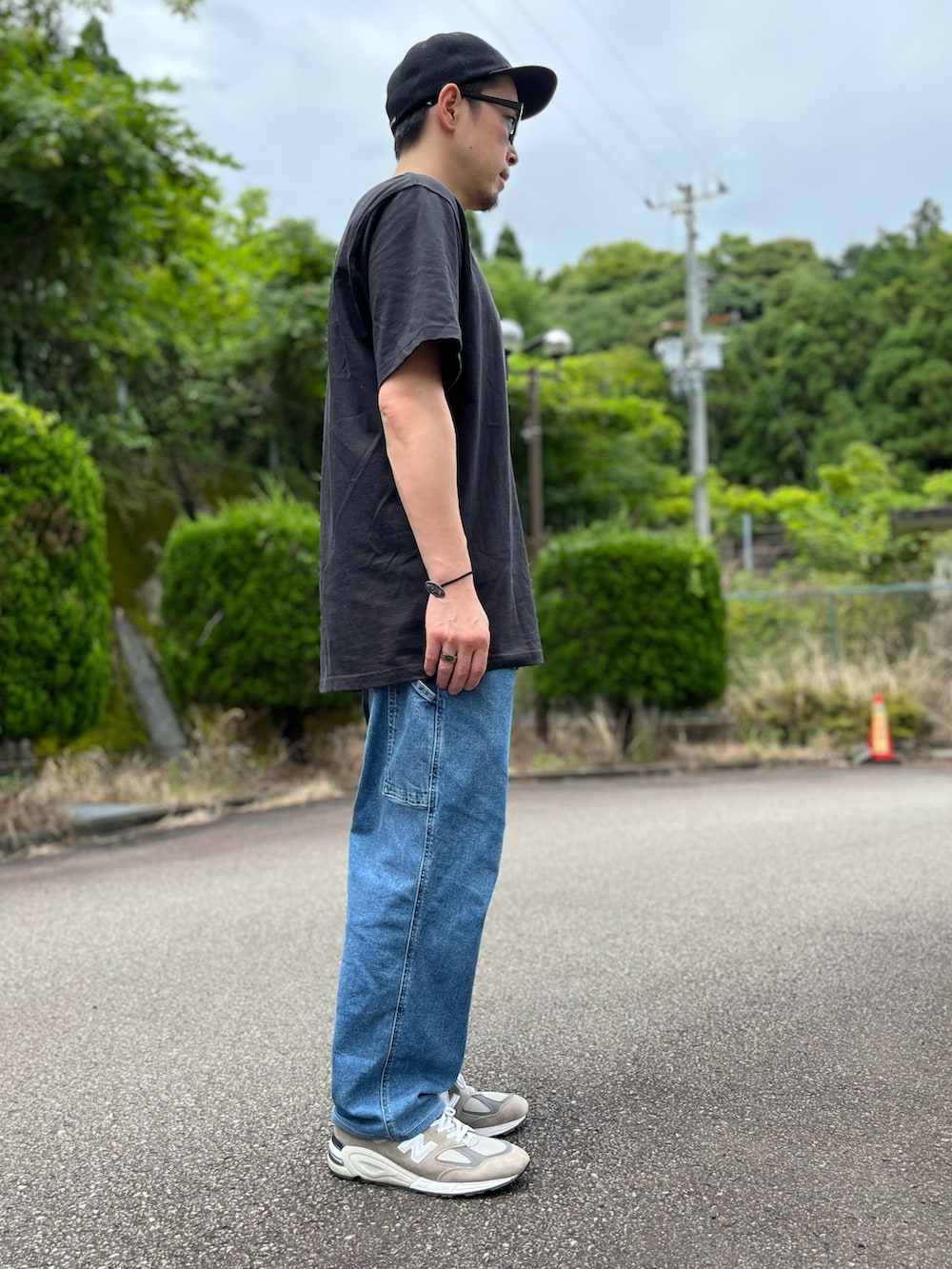 ブラック系のTシャツ/カットソー、ブルー系のパンツ、グレー系のスニーカーを着用したメンズの夏コーディネートの4枚目の写真