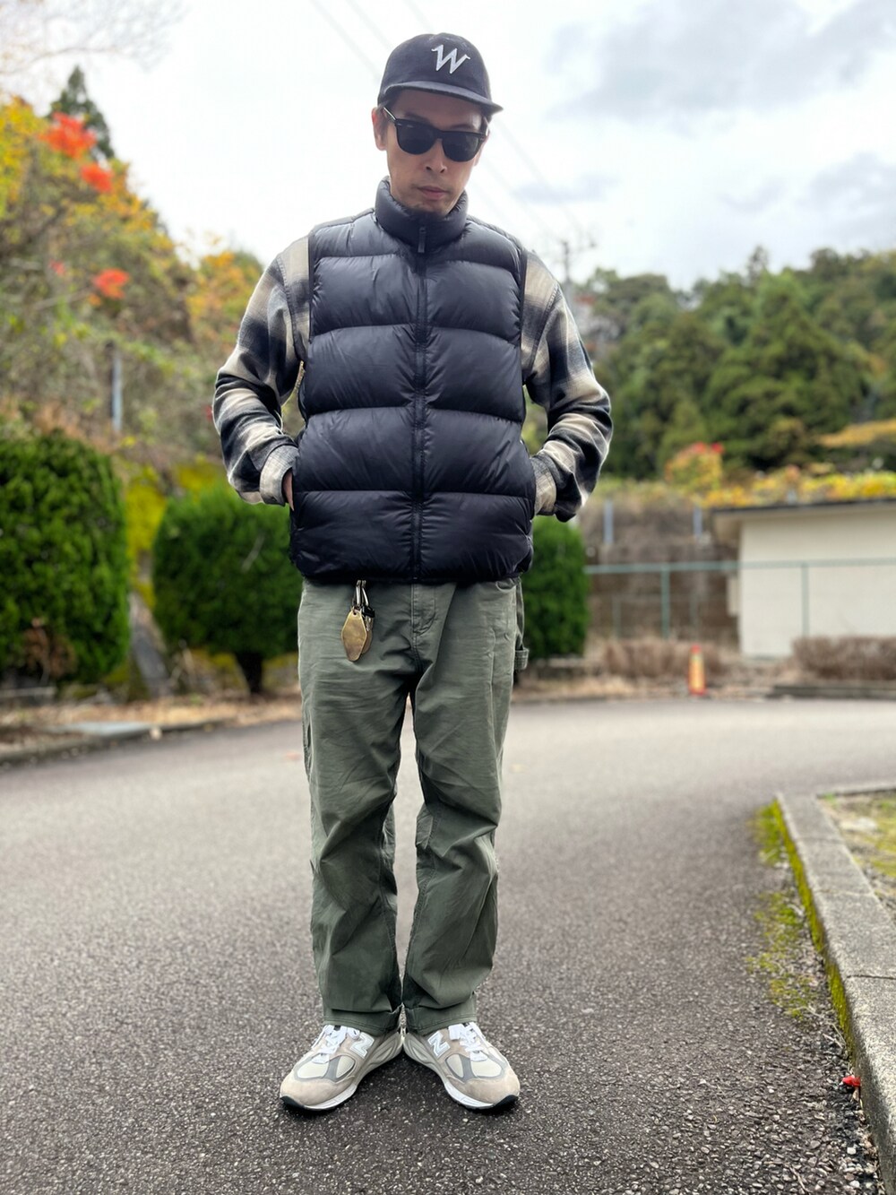 ブラック系のダウンベスト、ブラック系のトップス、グリーン系のパンツを着用したメンズの冬コーディネートの5枚目の写真
