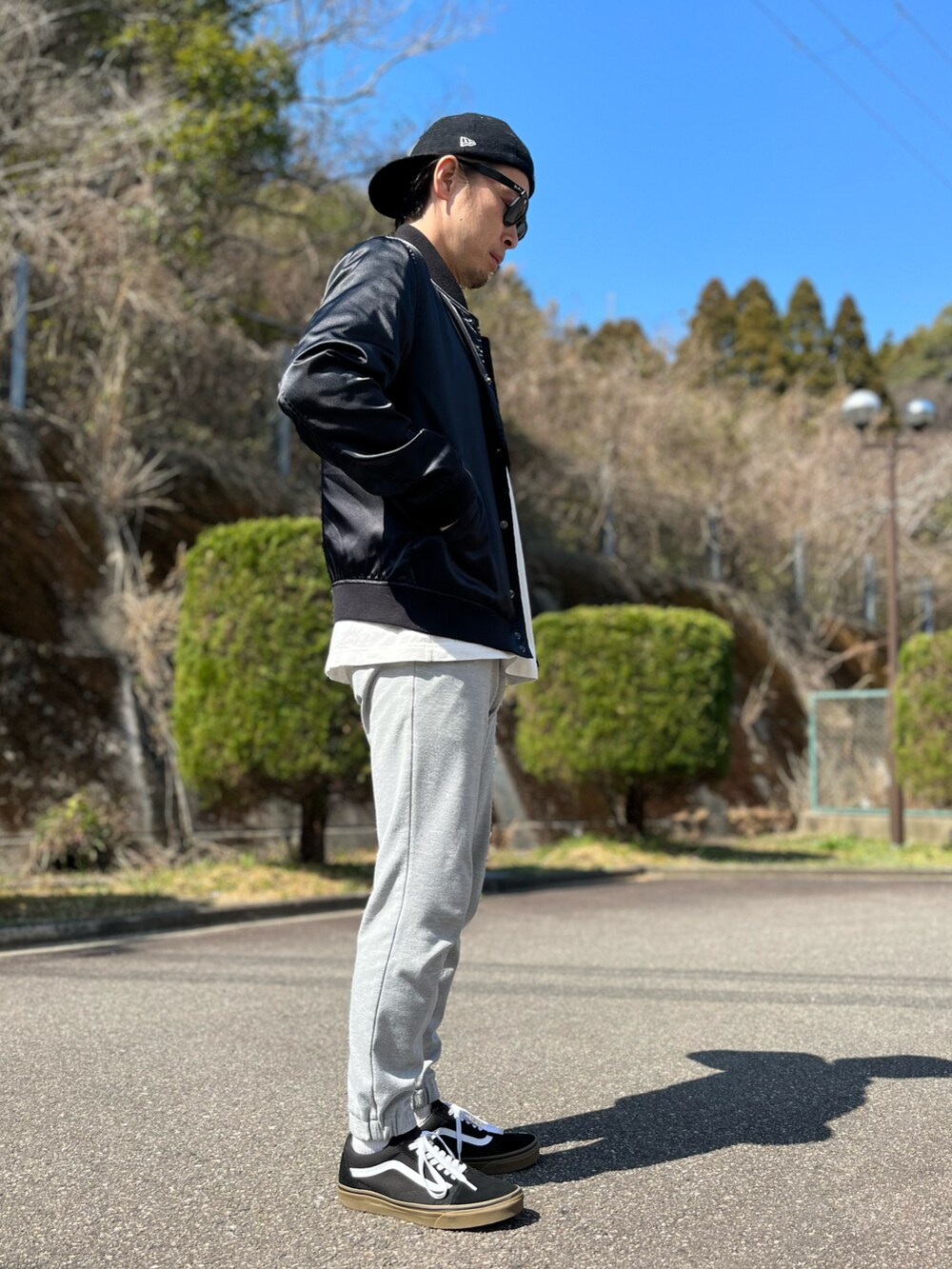 ホワイト系のTシャツ/カットソー、ブラック系のブルゾン、グレー系のスウェットパンツを着用したメンズの春コーディネートの3枚目の写真