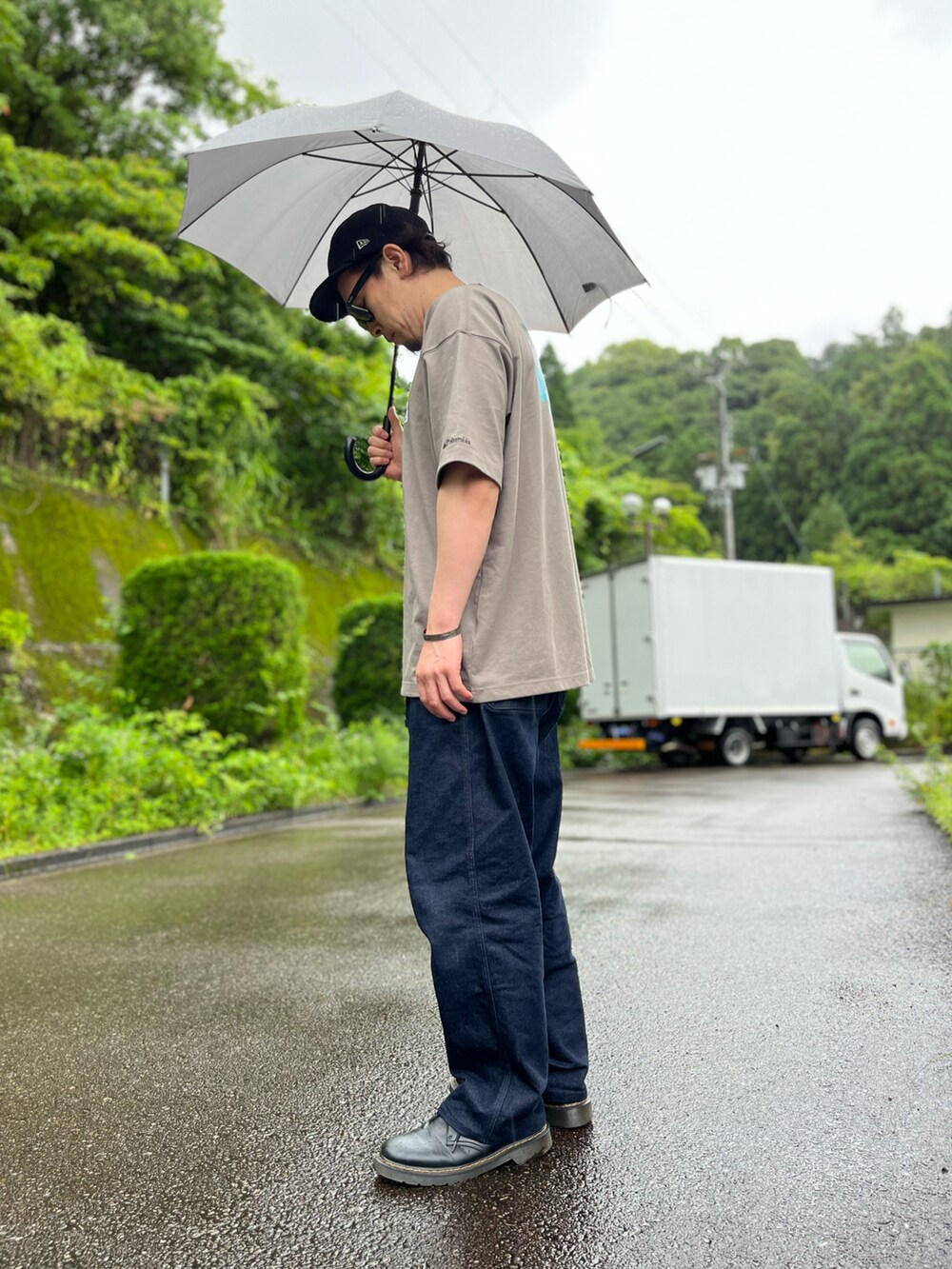 ブルー系のパンツ、ブラック系のブーツ、ブラウン系のTシャツ/カットソーを着用したメンズの夏コーディネートの3枚目の写真
