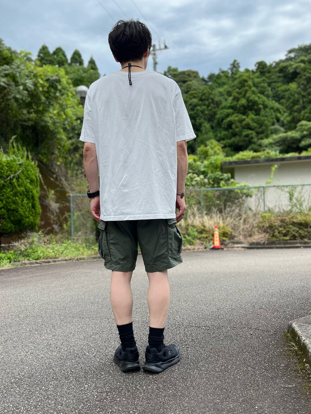 ホワイト系のTシャツ/カットソー、グリーン系のその他パンツ、ブラック系のスニーカーを着用したメンズの夏コーディネートの3枚目の写真