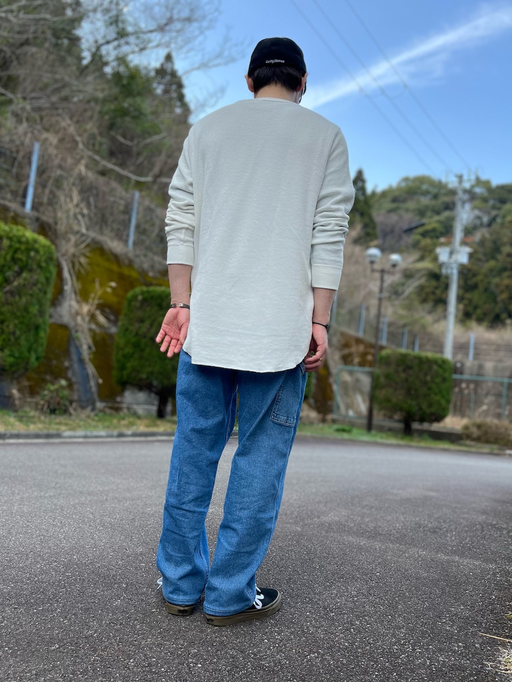 ホワイト系のTシャツ/カットソー、ブルー系のパンツ、ブラック系のスニーカーを着用したメンズの春コーディネートの3枚目の写真