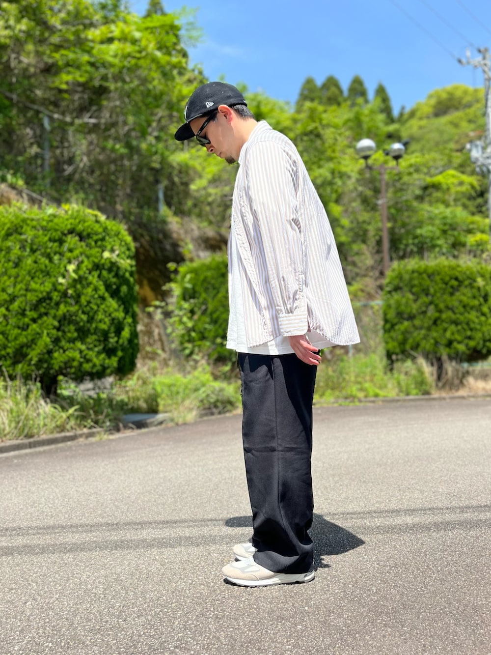 ホワイト系のTシャツ/カットソー、ブラウン系のシャツ/ブラウス、ブラック系のスラックスを着用したメンズの春コーディネートの4枚目の写真