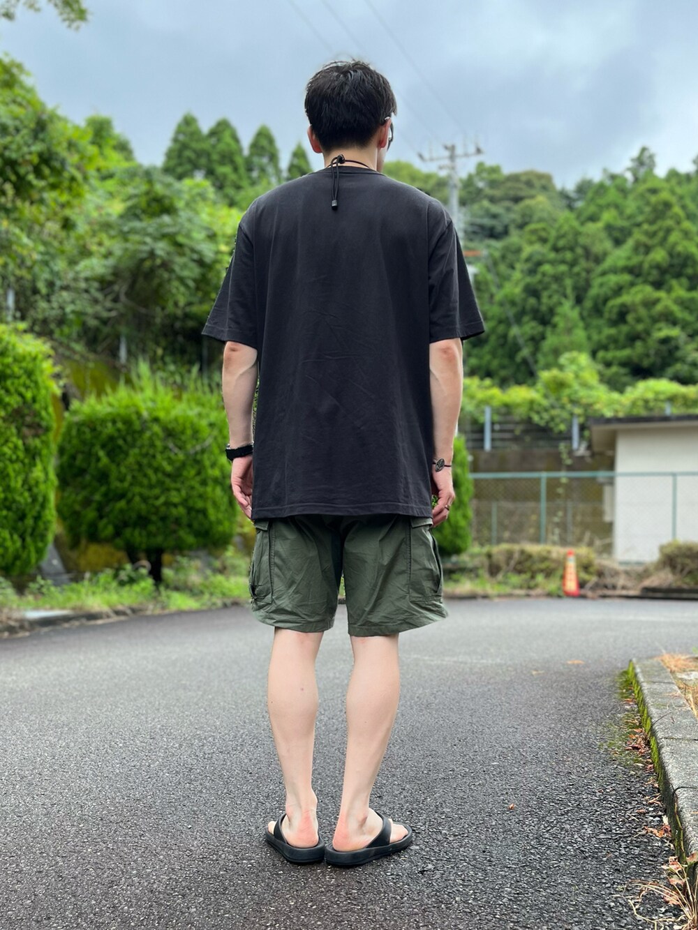 ブラック系のTシャツ/カットソー、グリーン系のその他パンツ、ブラック系のサンダルを着用したメンズの夏コーディネートの3枚目の写真