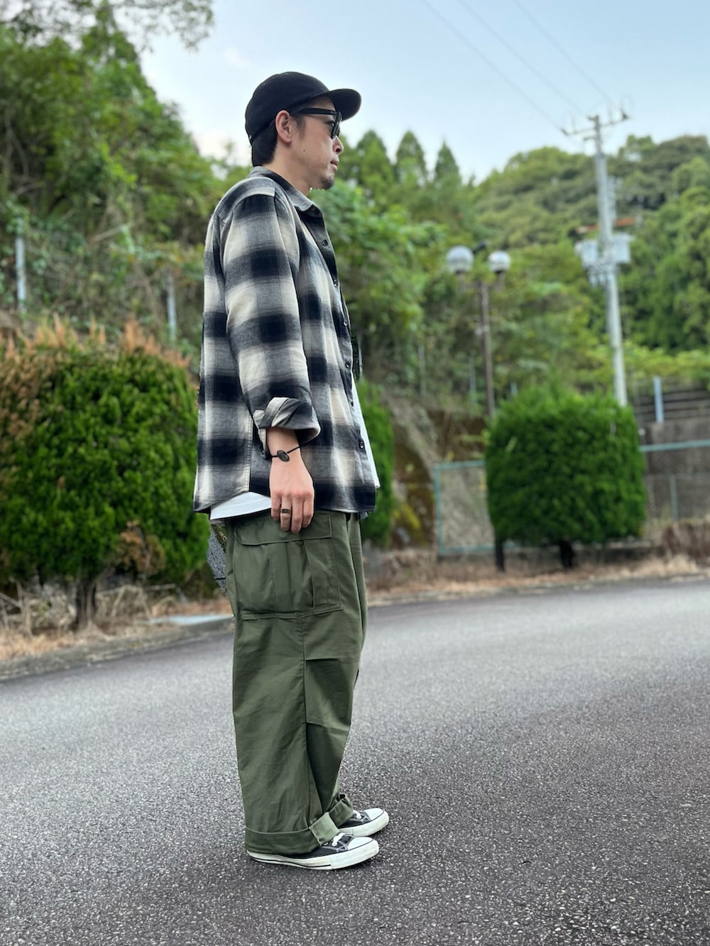 ホワイト系のTシャツ/カットソー、ブラック系のトップス、グリーン系のカーゴパンツを着用したメンズの秋コーディネートの2枚目の写真