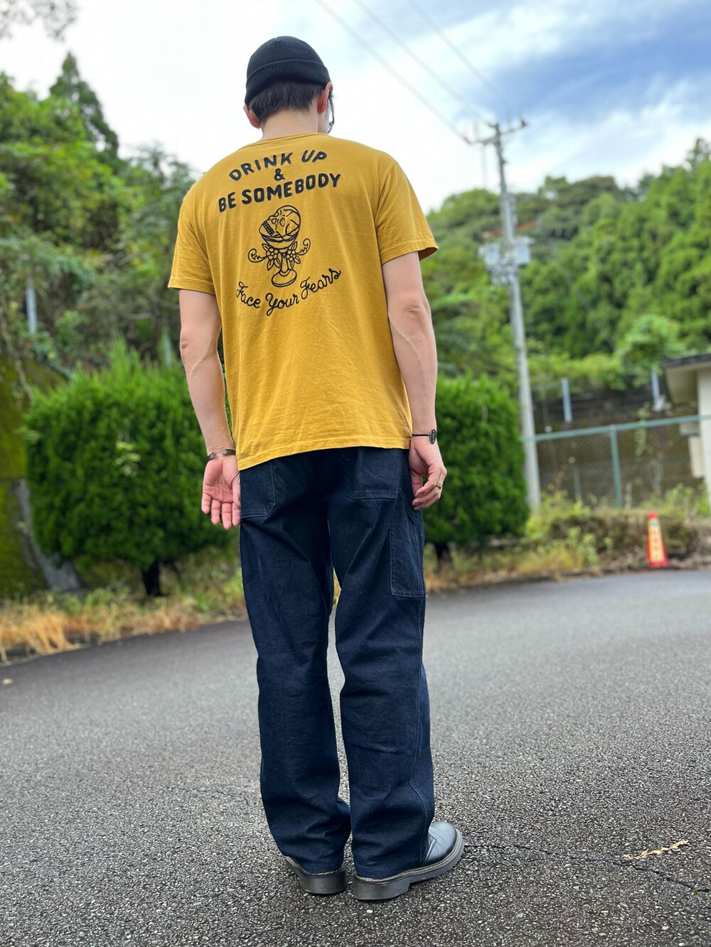 イエロー系のTシャツ/カットソー、ブルー系のパンツ、ブラック系のブーツを着用したメンズの秋コーディネートの3枚目の写真