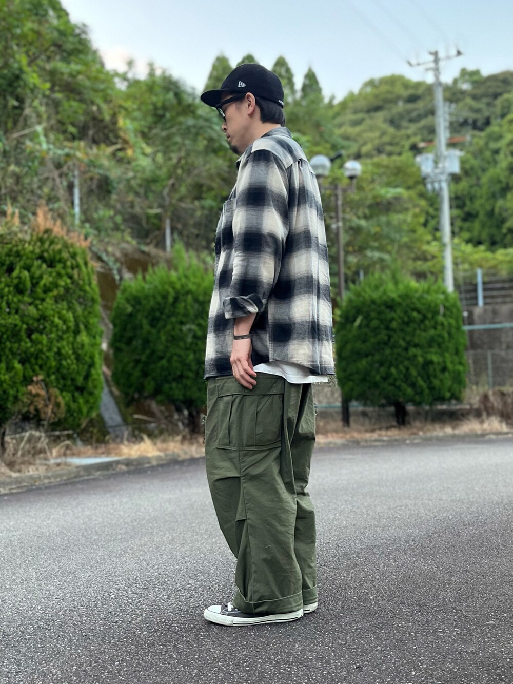 ホワイト系のTシャツ/カットソー、ブラック系のトップス、グリーン系のカーゴパンツを着用したメンズの秋コーディネートの4枚目の写真