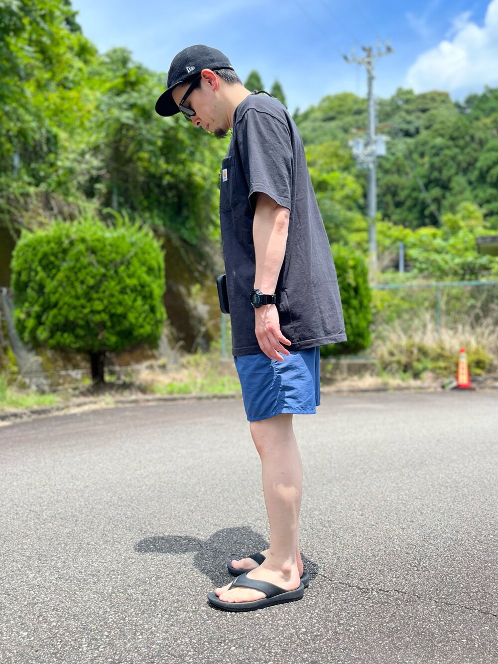 ブラック系のTシャツ/カットソー、ブルー系のパンツ、ブラック系のサンダルを着用したメンズの夏コーディネートの5枚目の写真