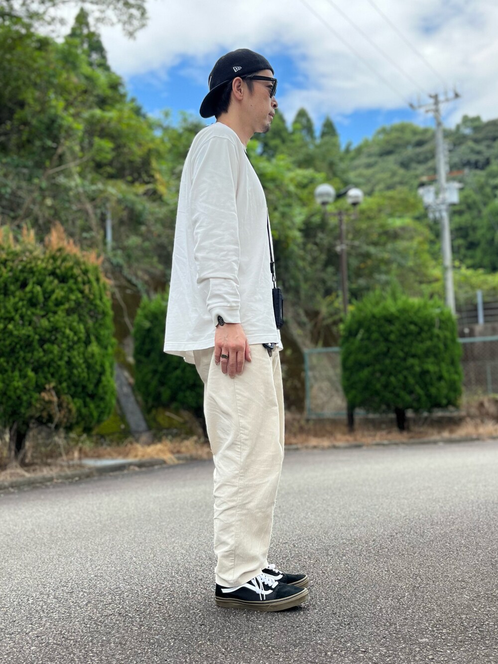 ホワイト系のTシャツ/カットソー、ホワイト系のパンツ、ブラック系のスニーカーを着用したメンズの秋コーディネートの4枚目の写真