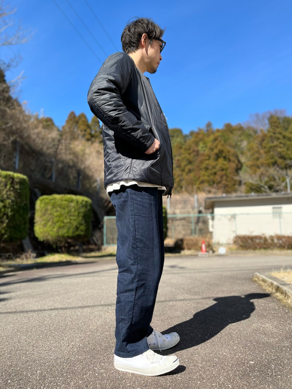 ホワイト系のTシャツ/カットソー、ブラック系のバッグ、ブルー系のパンツを着用したメンズの冬コーディネートの3枚目の写真