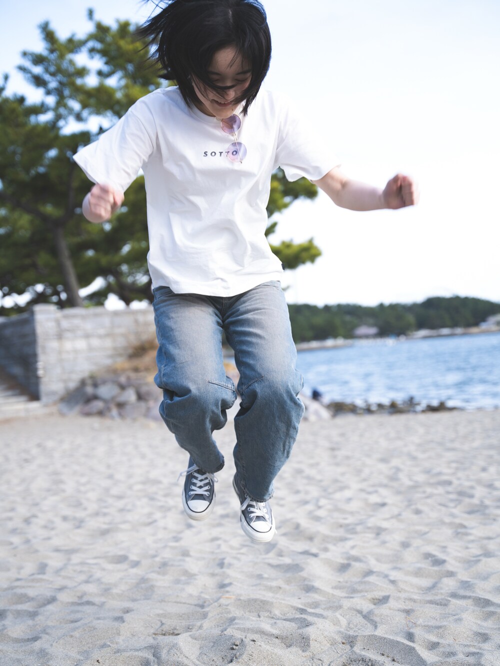 ブルー系のデニムパンツ、ホワイト系のTシャツ/カットソーを着用したレディースの秋コーディネートの2枚目の写真