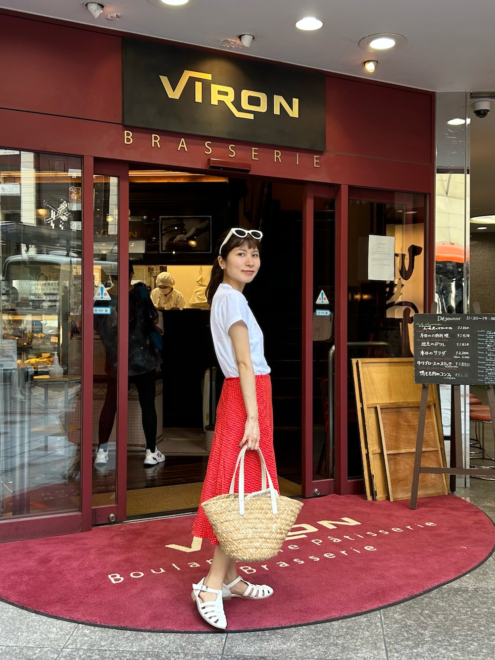 ベージュ系のバッグ、ホワイト系のTシャツ/カットソー、レッド系のスカートを着用したレディースの秋コーディネートの2枚目の写真