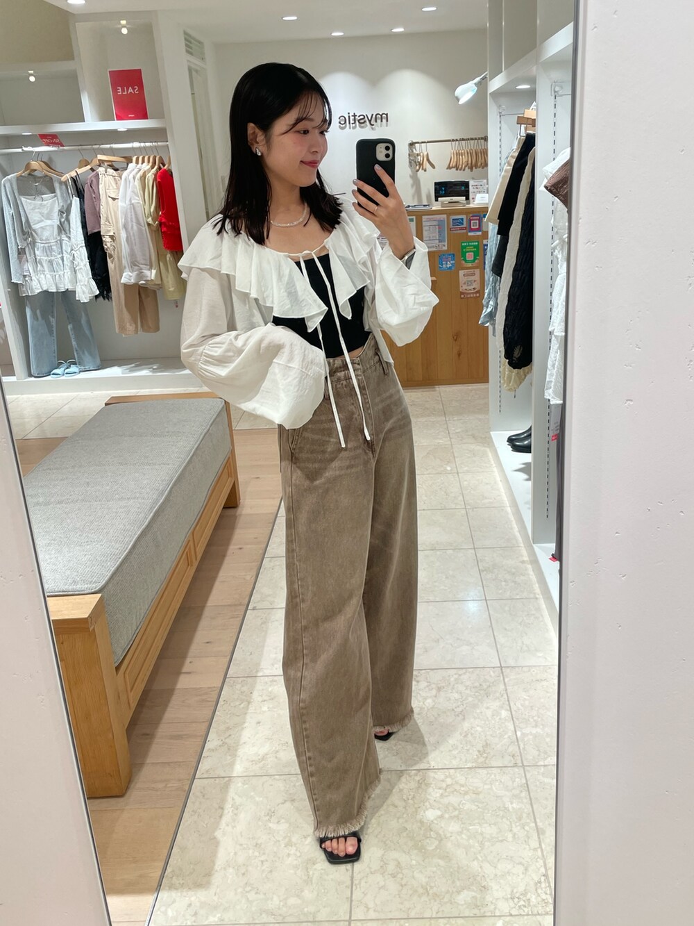 ブラック系のトートバッグ、ブラウン系のデニムパンツ、ブラック系のキャミソールを着用したレディースの夏コーディネートの4枚目の写真