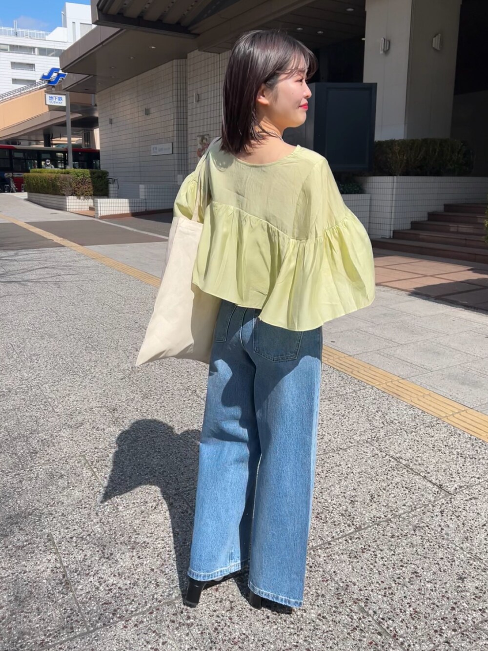 グリーン系のシャツ/ブラウス、ブルー系のデニムパンツを着用したレディースの春コーディネートの3枚目の写真