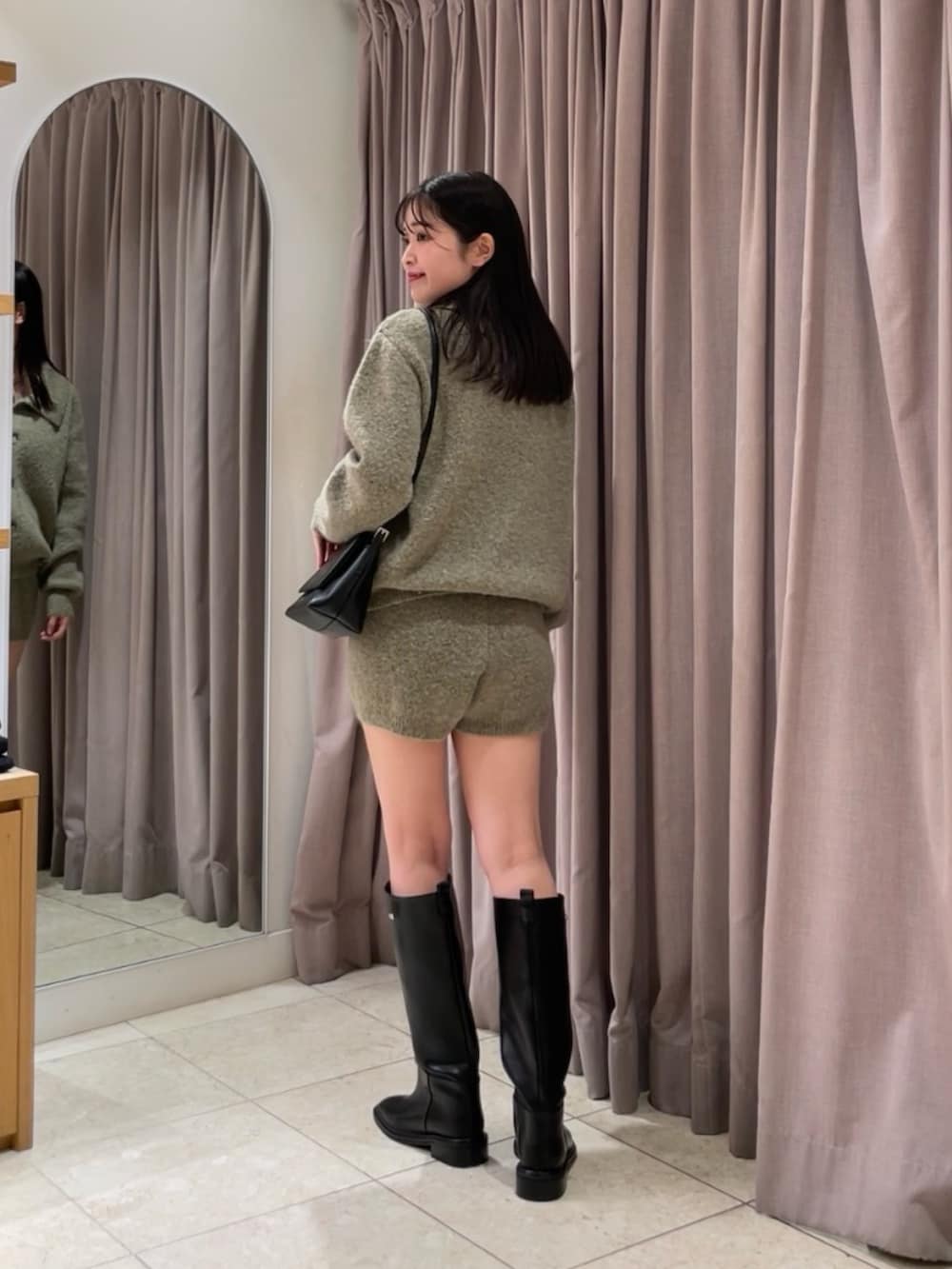 ベージュ系のカーディガン/ボレロ、ベージュ系のその他パンツ、ブラック系のブーツを着用したレディースの秋コーディネートの2枚目の写真