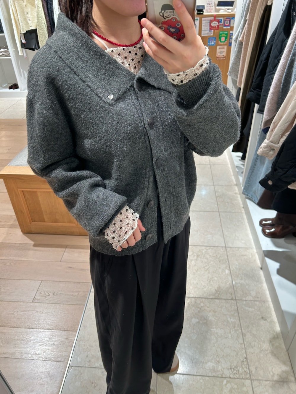 ブラック系のスラックス、グレー系のカーディガン/ボレロ、ホワイト系のTシャツ/カットソーを着用したレディースの冬コーディネートの2枚目の写真