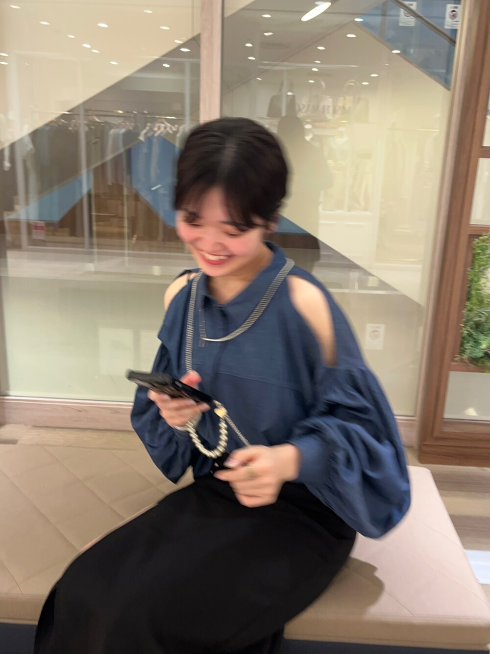 ブラック系のスカート、ブルー系のシャツ/ブラウスを着用したレディースの春コーディネートの2枚目の写真