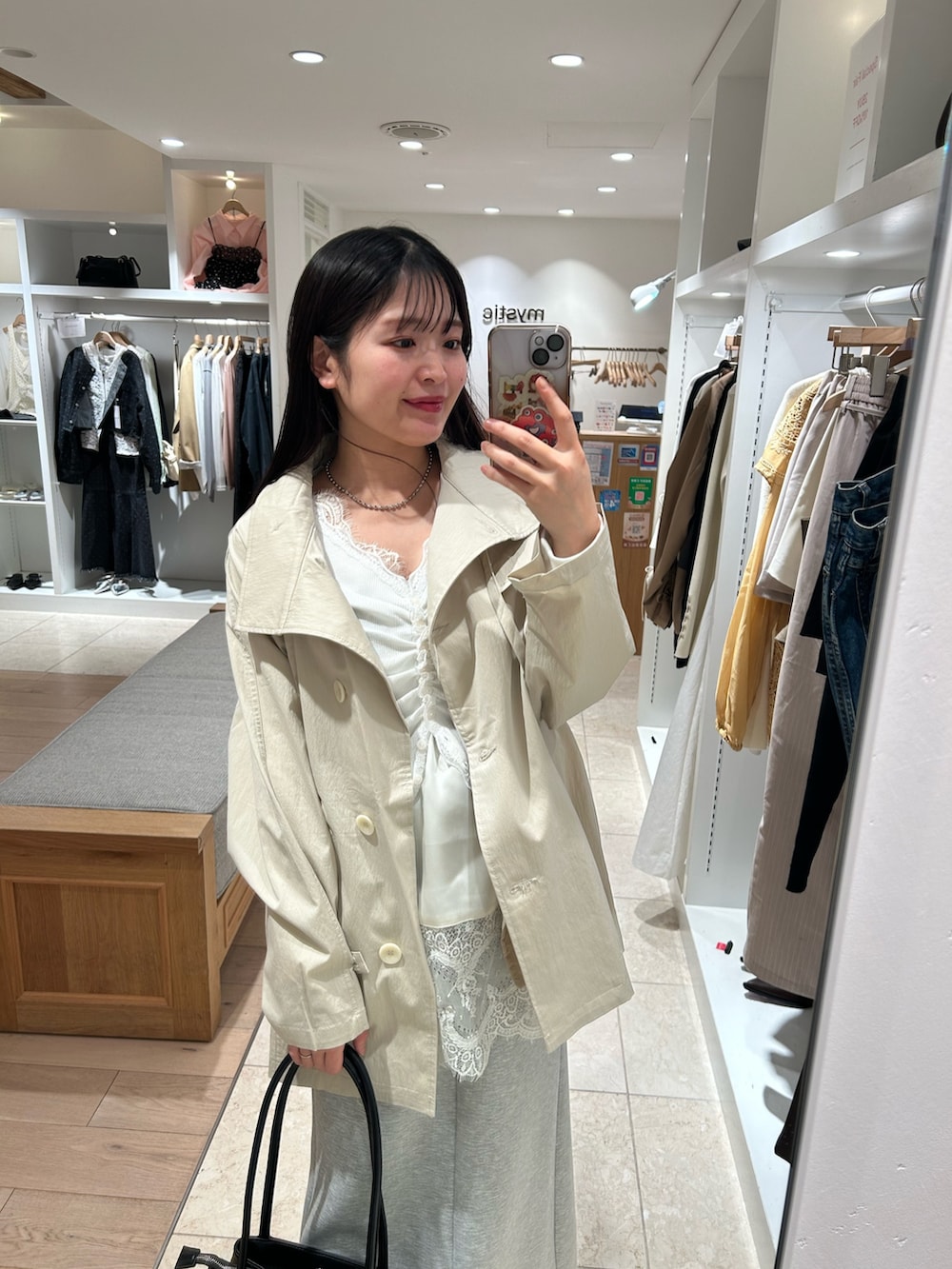 ホワイト系のキャミソール、ホワイト系のトレンチコート、グレー系のスカートを着用したレディースの春コーディネートの2枚目の写真