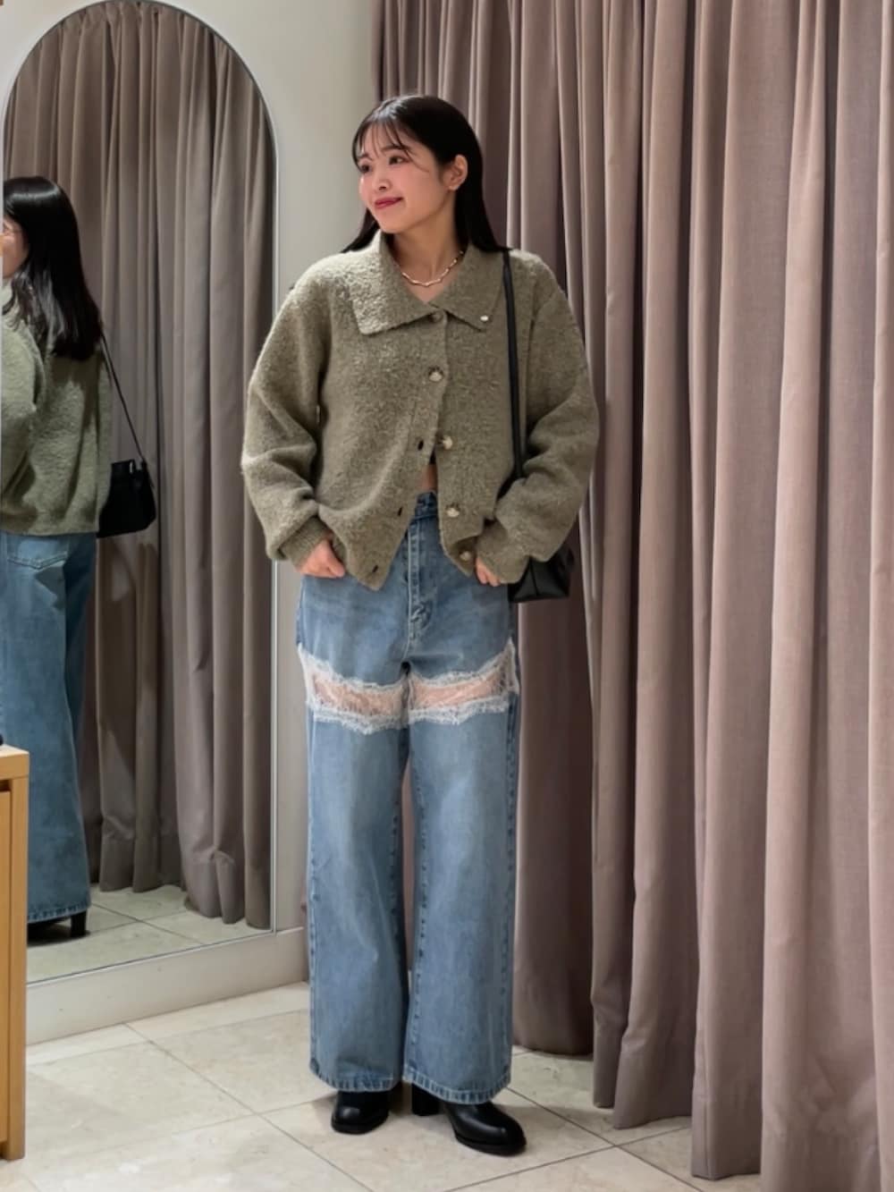 ブルー系のデニムパンツ、ブラック系のブーツ、ベージュ系のカーディガン/ボレロを着用したレディースの秋コーディネートの4枚目の写真