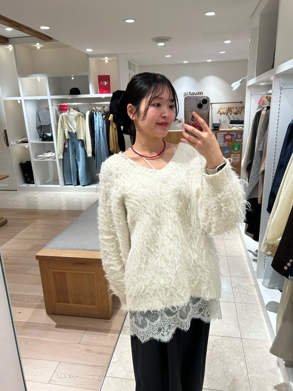 ホワイト系のニット/セーター、ホワイト系のキャミソール、ブラック系のスラックスを着用したレディースの冬コーディネートの2枚目の写真