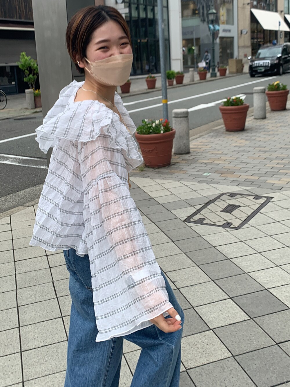ホワイト系のシャツ/ブラウス、ブルー系のデニムパンツ、ブラウン系のサンダルを着用したレディースの夏コーディネートの3枚目の写真