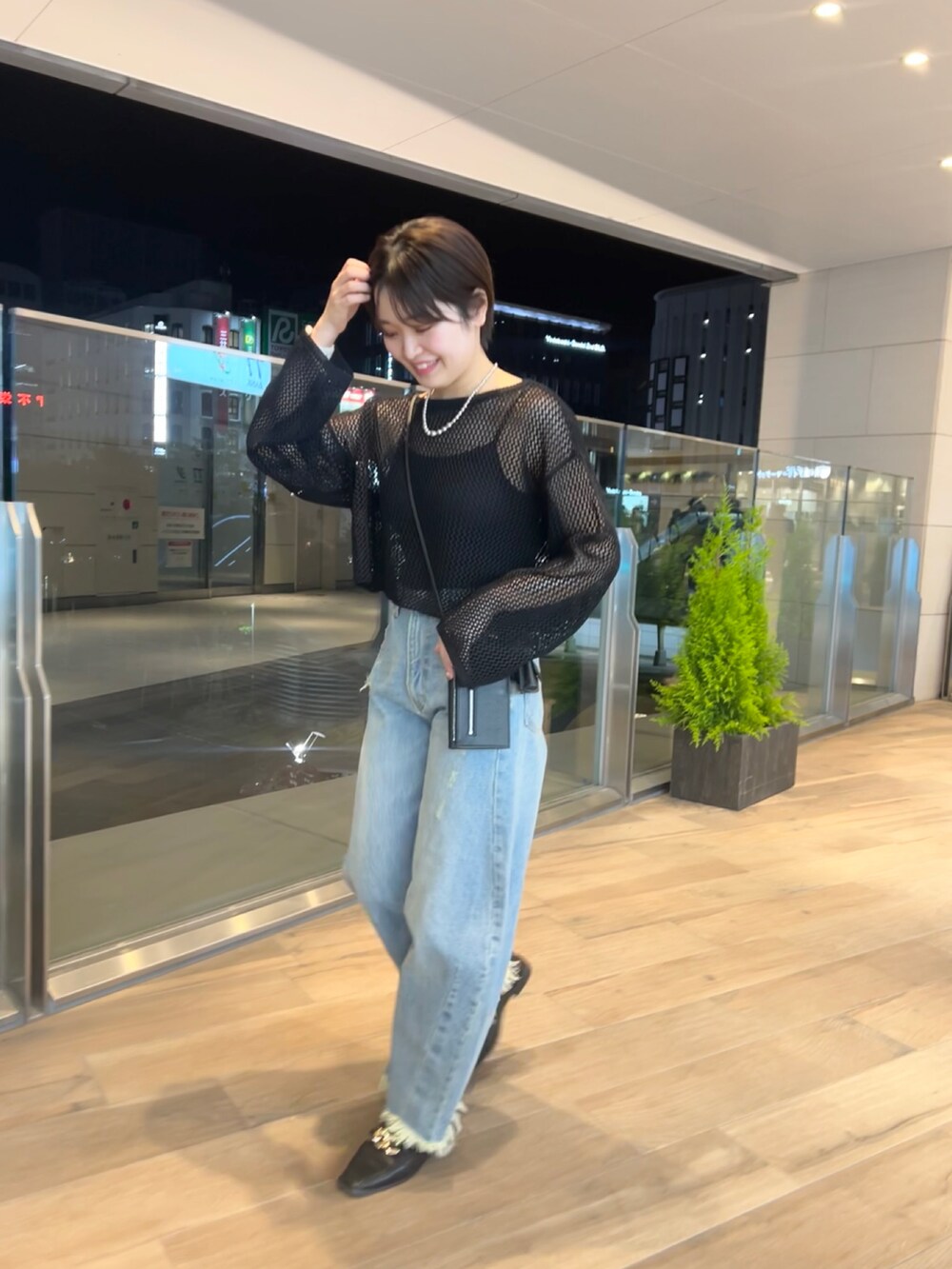 ブラック系のローファー、ブルー系のデニムパンツ、ブラック系のニット/セーターを着用したレディースの春コーディネートの3枚目の写真