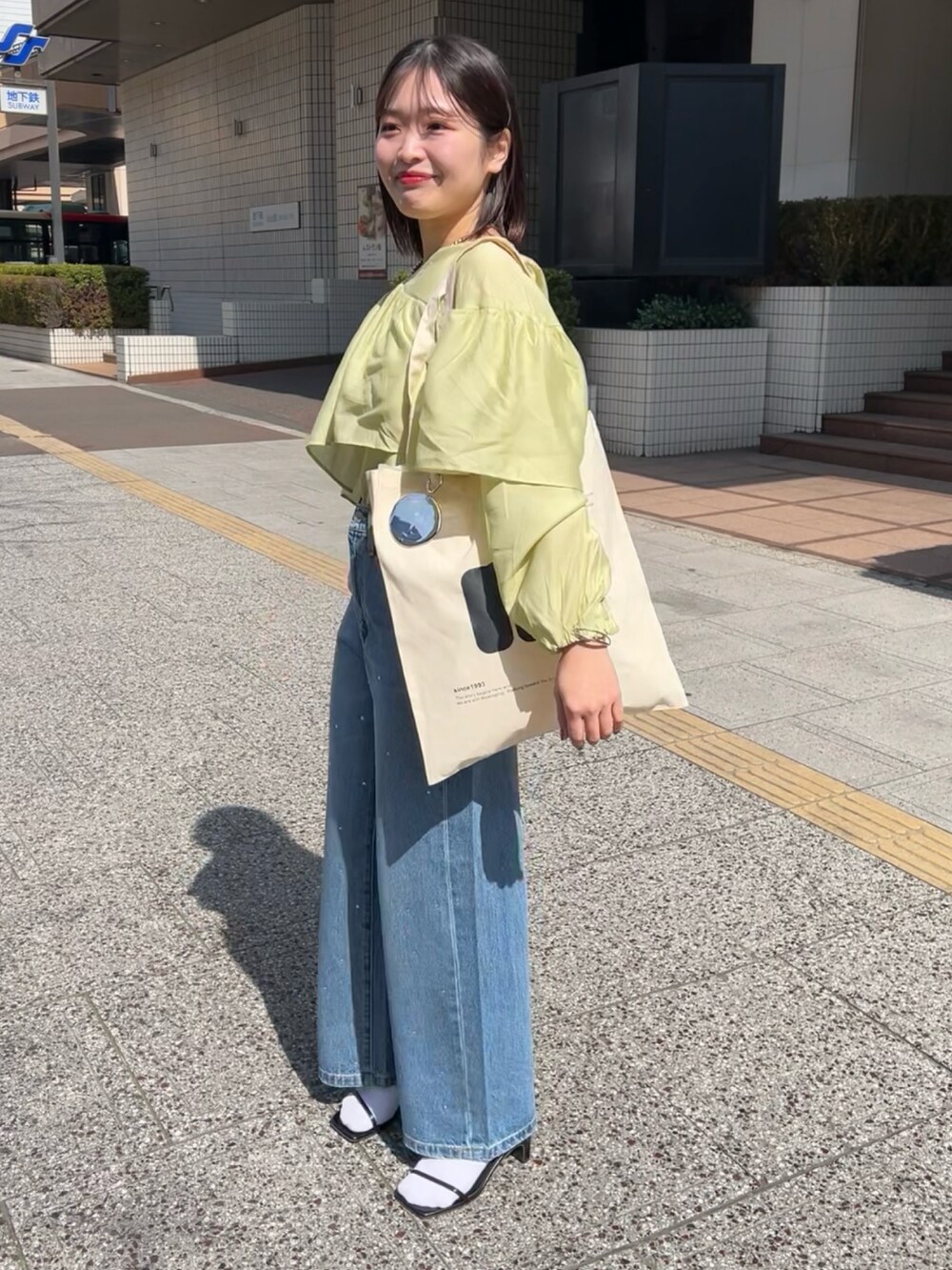 グリーン系のシャツ/ブラウス、ブルー系のデニムパンツを着用したレディースの春コーディネートの4枚目の写真