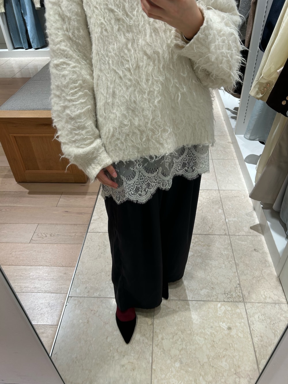 ホワイト系のニット/セーター、ホワイト系のキャミソール、ブラック系のスラックスを着用したレディースの冬コーディネートの3枚目の写真