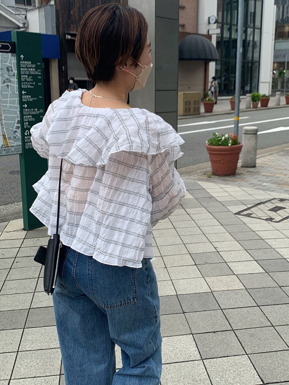 ホワイト系のシャツ/ブラウス、ブルー系のデニムパンツ、ブラウン系のサンダルを着用したレディースの夏コーディネートの4枚目の写真