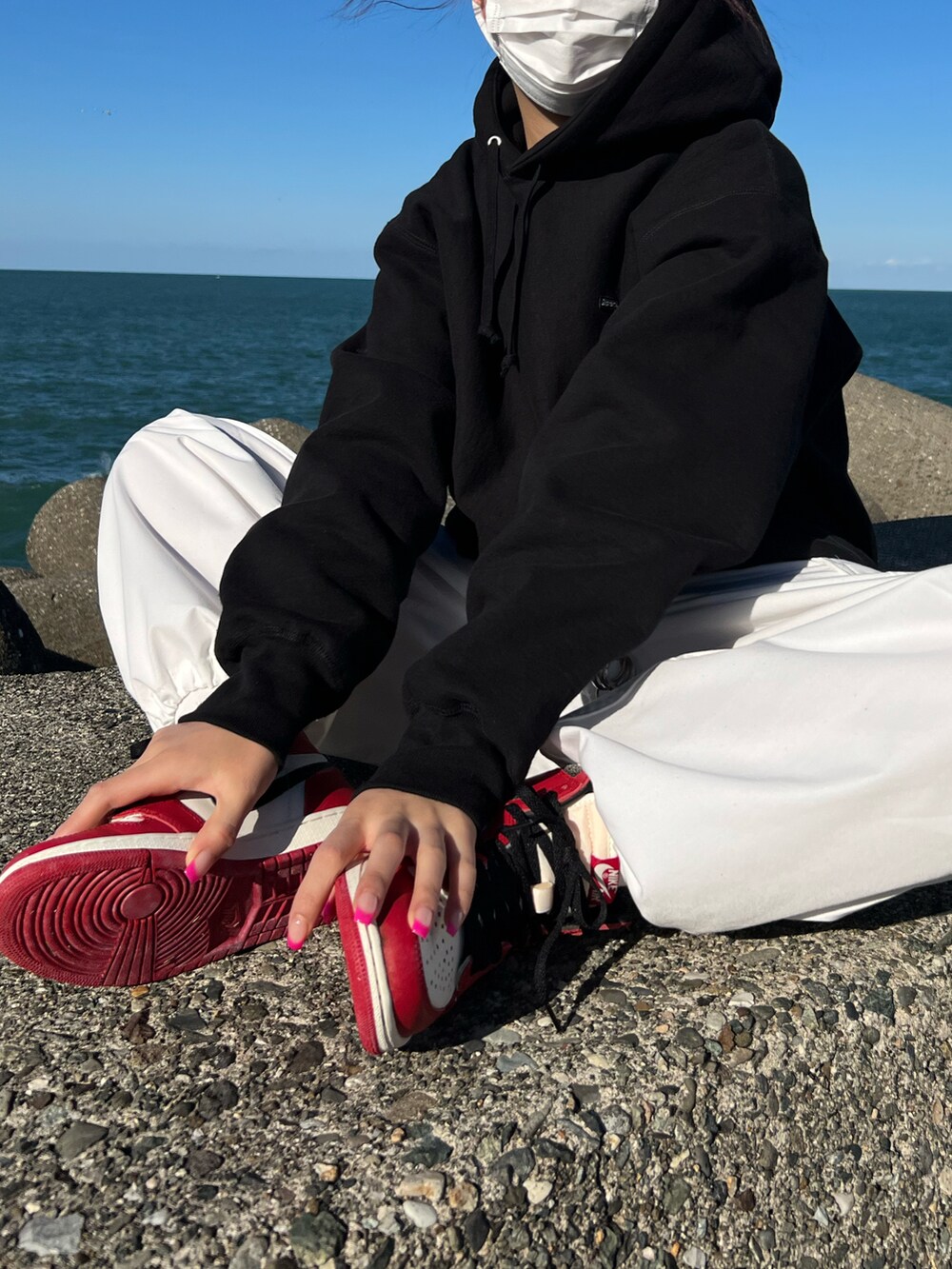 ブラック系のパーカー、レッド系のスニーカー、レッド系のスニーカーを着用したレディースの秋コーディネートの5枚目の写真