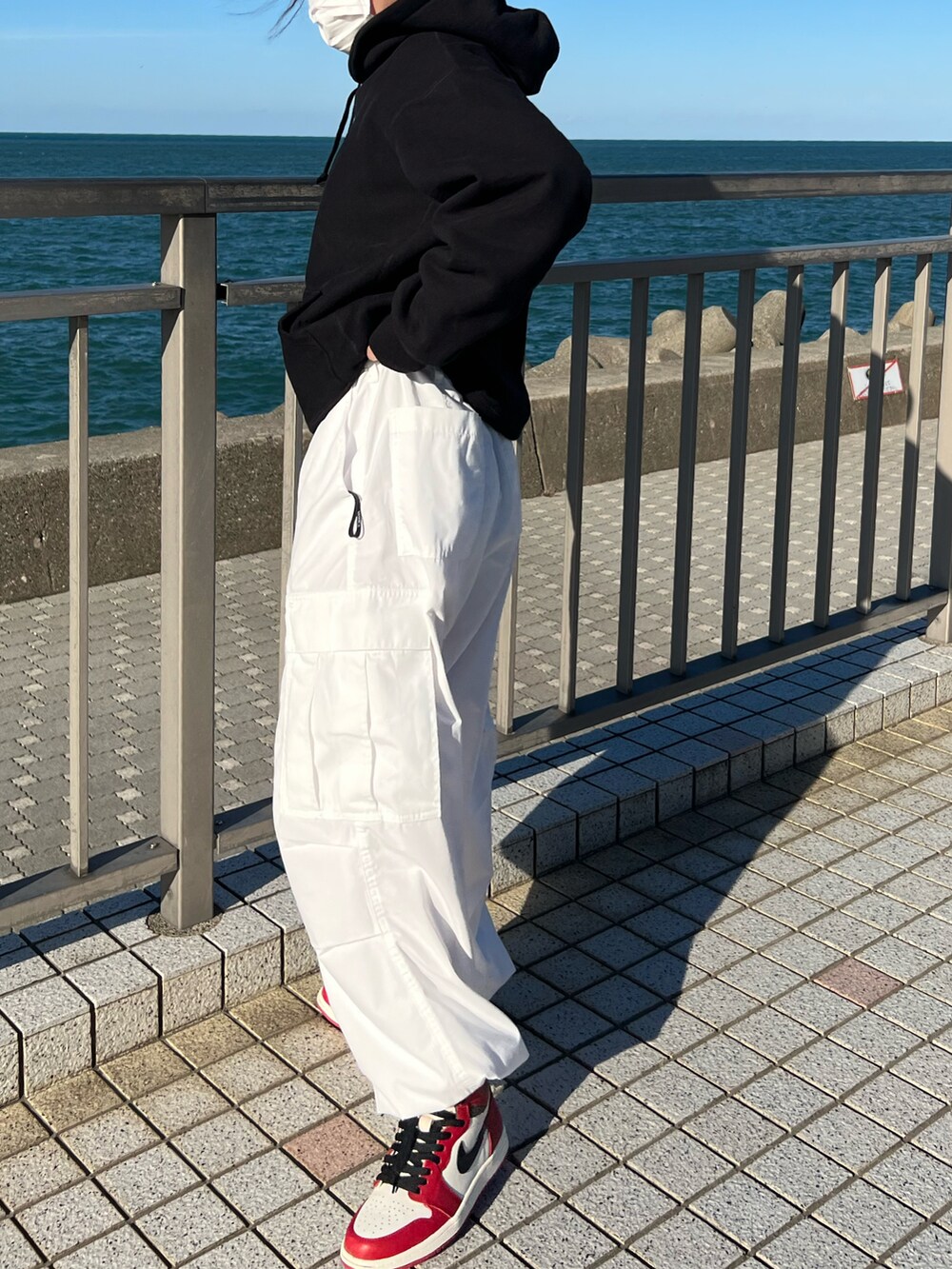 ブラック系のパーカー、レッド系のスニーカー、レッド系のスニーカーを着用したレディースの秋コーディネートの3枚目の写真