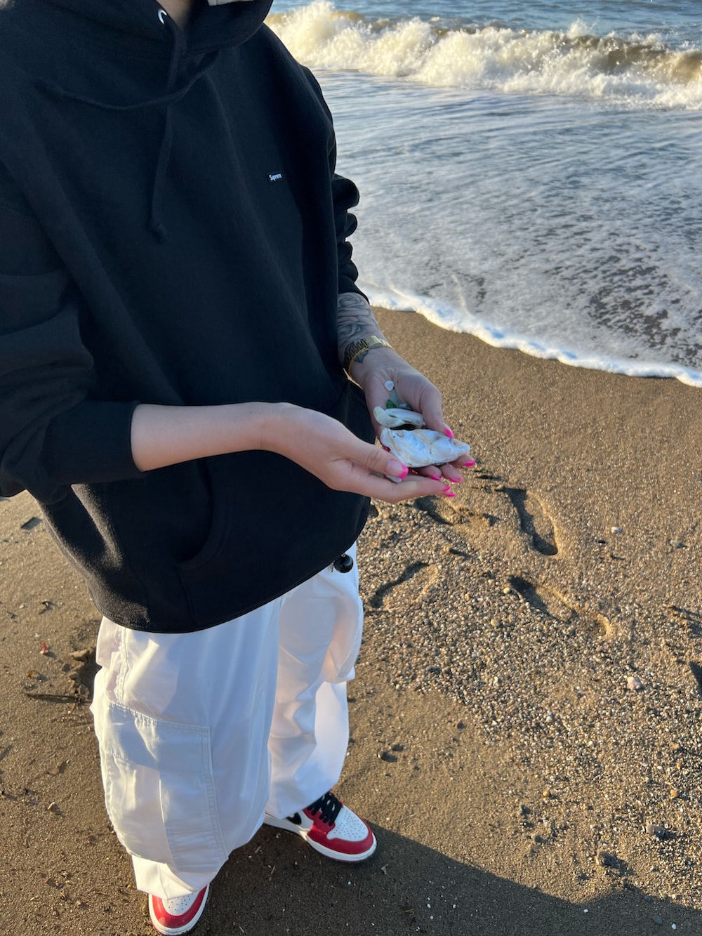 ブラック系のパーカー、レッド系のスニーカー、レッド系のスニーカーを着用したレディースの秋コーディネートの2枚目の写真