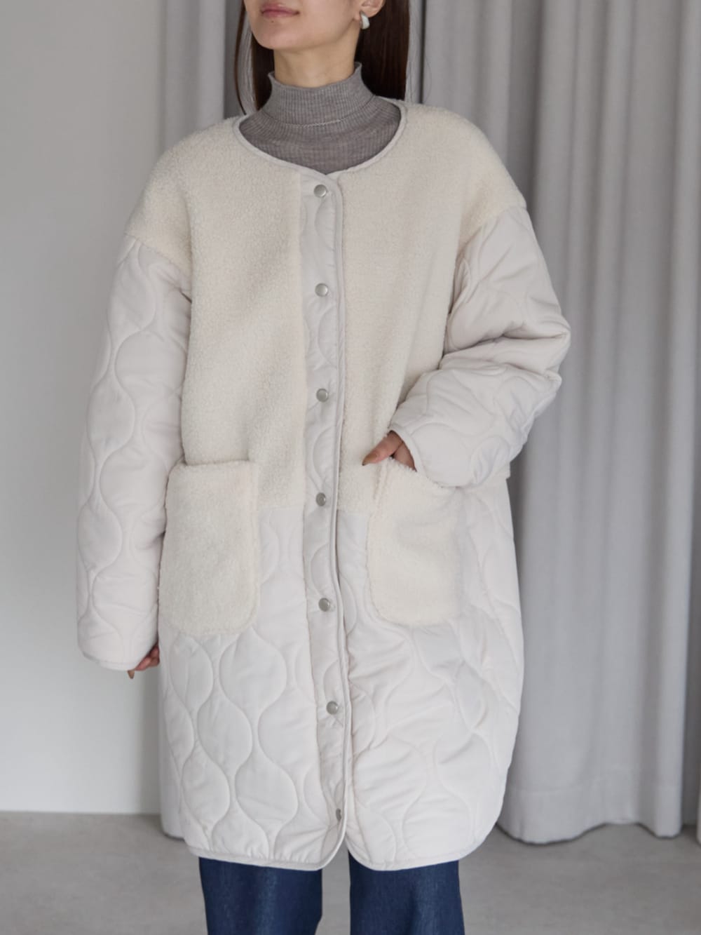 ブルー系のデニムパンツ、ホワイト系のノーカラーコートを着用したレディースの冬コーディネートの2枚目の写真