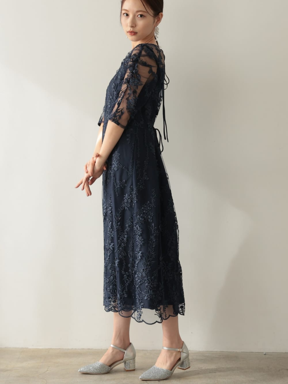 ブルー系のドレス、シルバー系のパンプスを着用したレディースの冬コーディネートの2枚目の写真