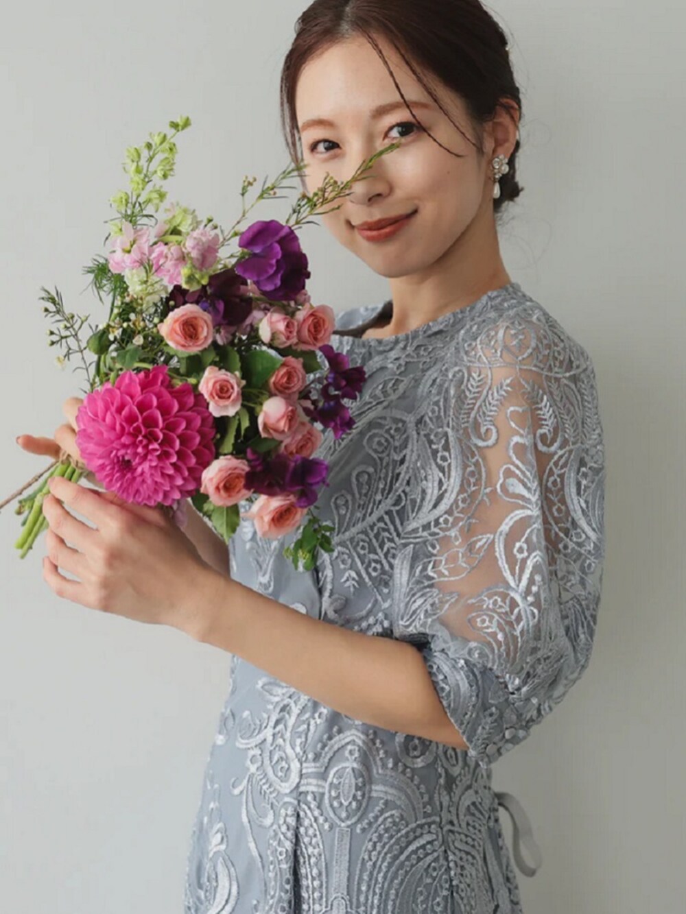 グレー系のドレス、シルバー系のパンプスを着用したレディースの冬コーディネートの2枚目の写真